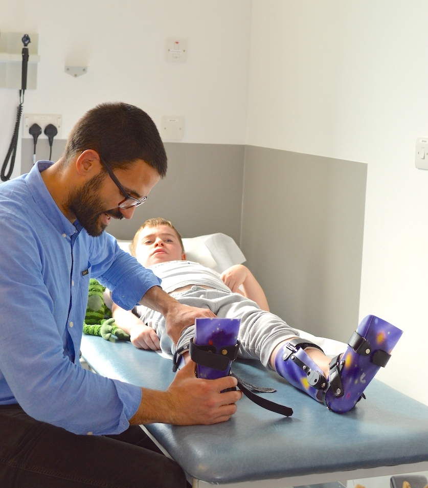 A doctor treating a boy with leg splints